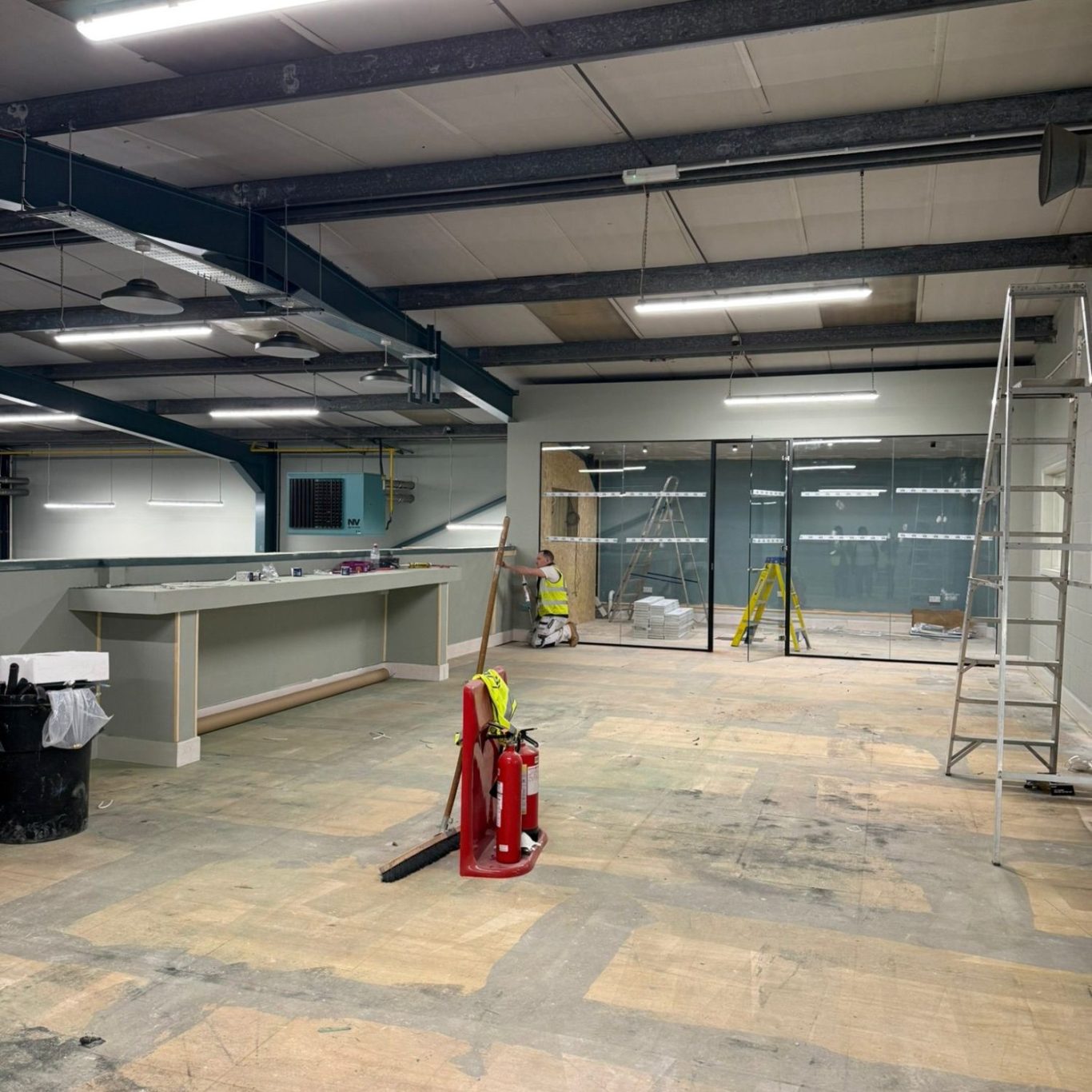 Professional Commercial Cleaning Services – Before & After Office Clean Empty office space undergoing renovation with tools and scaffolding visible.
